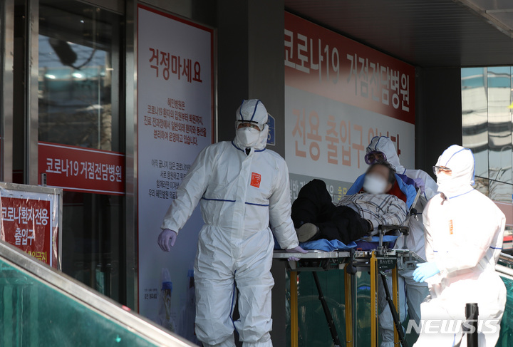 [서울=뉴시스] 조수정 기자 = 지난달 6일 오전 코로나19 거점전담병원인 서울 광진구 혜민병원에서 서울소방 119 구급대원들이 확진자를 이송하고 있다. 2022.02.07. chocrystal@newsis.com