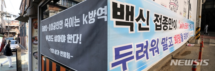 [서울=뉴시스] 백동현 기자 = 방역패스 관련 논란이 한창인 지난 6일 오후 서울 광진구 건대입구역 인근에 방역조치에 대한 상반된 의견을 적은 현수막들이 걸려있다. 2022.01.06. livertrent@newsis.com