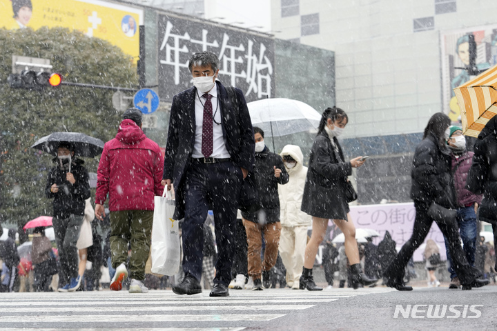 [도쿄=AP/뉴시스]지난 6일 일본 도쿄 시부야 스크램볼 교차로를 마스크를 착용한 사람들이 걷고 있다. 2023.01.25.