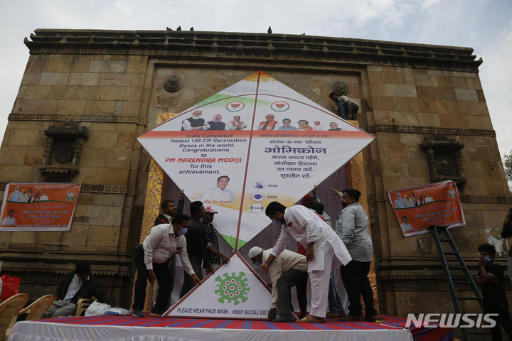 [아흐메다바드(인도)=AP/뉴시스]인도 아흐메다바드에서 6일 사람들이 코로나19에 대한 경각심을 높이기 위해 만든 대형 연을 날릴 준비를 하고 있다. 이탈리아 베로나에서 전세기 편으로 5일 오후 인도 북부 암리차르에 도착한 총 179명의 승객들 가운데 125명이 코로나19 양성 반응을 보였다고 BBC가 6일 보도했다. 인도 보건 당국은 이들 모두 격리될 것이라고 밝혔다. 2022.1.6