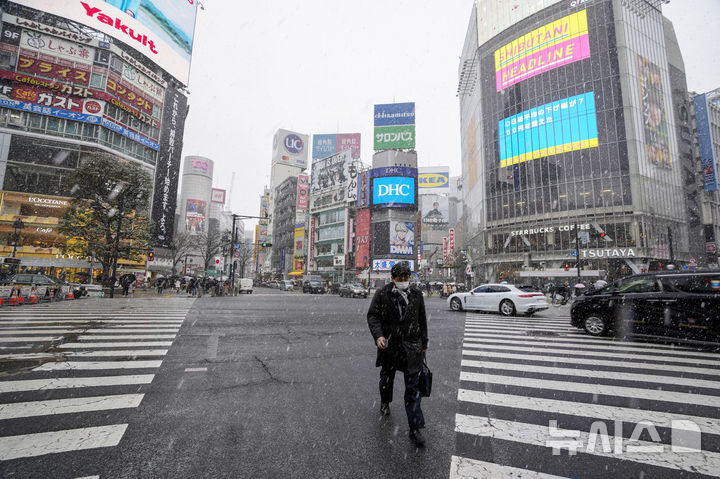 [도쿄=AP/뉴시스] 한 행인이 지난 2022년 1월 6일 일본 도쿄 시부야의 횡단보도를 건너고 있다. 2026.03.25. photo@newsis.com