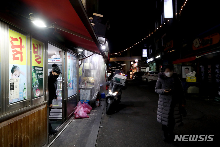 [서울=뉴시스] 김병문 기자 = 지난달 6일 오후 영업제한시간 이후 서울 중구 백학시장 한 식당에서 강화된 사회적 거리두기 연장을 비판하는 점등시위를 하고 있다. 2022.01.06. dadazon@newsis.com