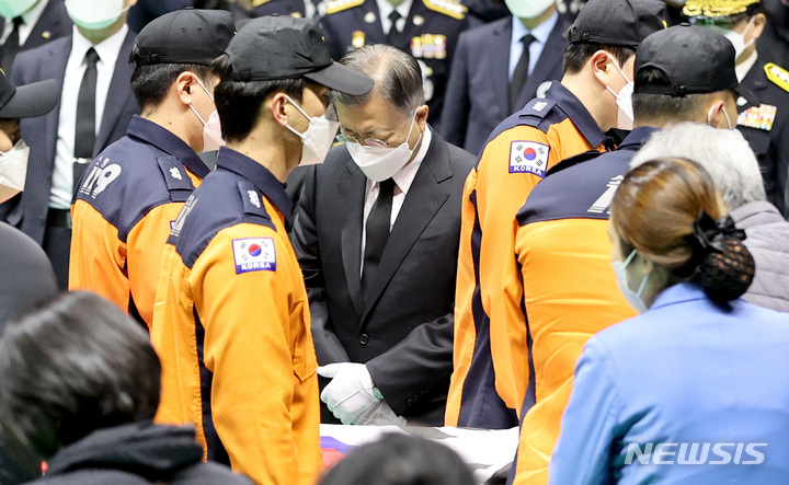 [평택=뉴시스] 경기사진공동취재단 = 문재인 대통령이 8일 오전 경기 평택시 이충문화체육센터에서 경기도청장으로 진행된 순직 소방공무원 합동 영결식에서 운구행렬을 바라보고 있다. 2022.01.08. photo@newsis.com