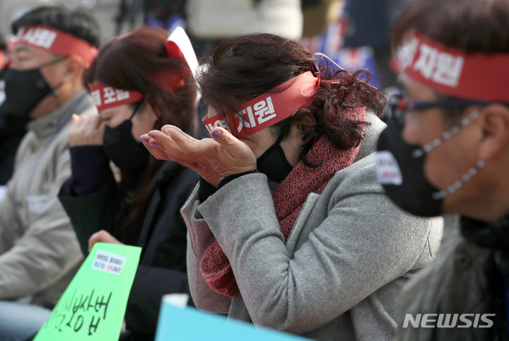 [서울=뉴시스] 조성우 기자 = 9일 오후 서울 종로구 보신각 앞에서 열린 한국여행업협회, 한국중소여행사연합회의 여행업 생존대책과 회복 방안을 요구하는 총궐기 대회에서 여행업 종사자가 호소문 낭독한 뒤 눈물을 훔치고 있다. 2022.01.09. xconfind@newsis.com