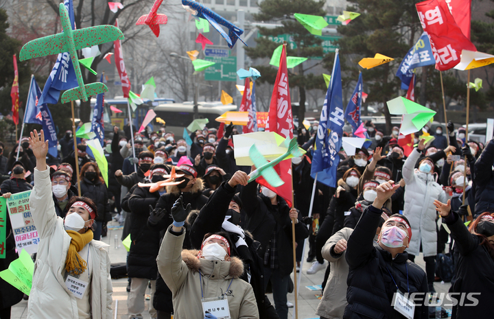 [서울=뉴시스] 조성우 기자 = 한국여행업협회, 한국중소여행사연합회 회원들이 9일 오후 서울 종로구 보신각 앞에서 열린 여행업 생존대책과 회복 방안을 요구하는 총궐기 대회에서 모형 비행기를 날리는 퍼포먼스를 하고 있다. 2022.01.09. xconfind@newsis.com