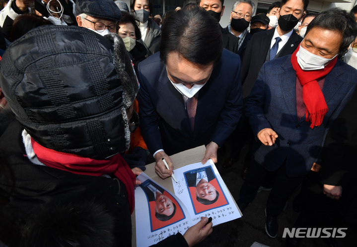 [인천=뉴시스] 국회사진기자단 = 윤석열 국민의힘 대선 후보가 10일 오전 인천역 앞 광장에서 산업화·교역일번지 인천지역 공약을 발표한 후 지지자에게 사인을 해주고 있다 2022.01.10. photo@newsis.com