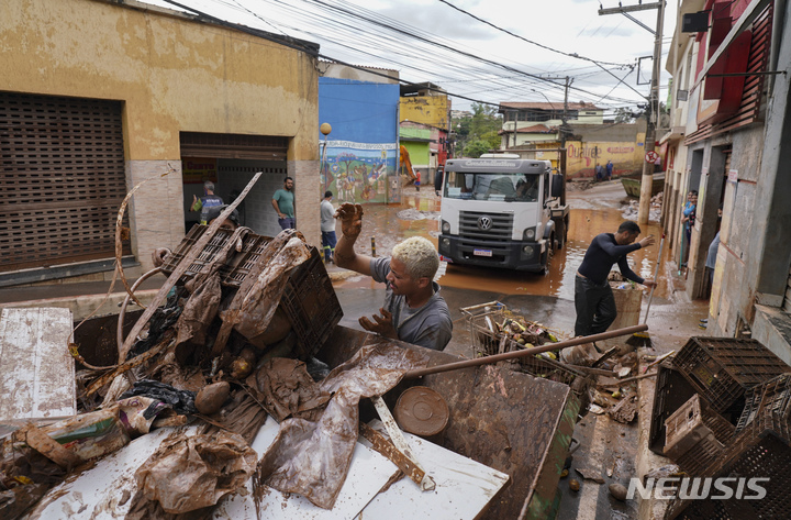 [하포주스=AP/뉴시스] 브라질 미나스 제라이스주 하포주스(Raposos) 마을 주민들이 2022년 1월 11일 홍수 잔해를 치우고 있다. 미나스 제라이스주에서는 거의 매년 폭우와 산사태 등으로 사상자가 속출했고 이번에도 25명이 죽고 45명이 실종상태라고 현지 당국이 밝혔다. 2026. 02. 25. 