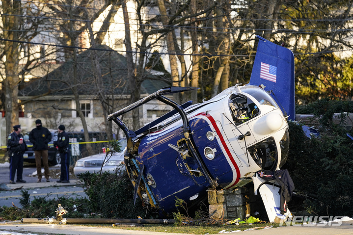 [어퍼다비=AP/뉴시스] 11일(현지시간) 미 펜실베이니아주 어퍼다비의 주택가에 의료용 헬리콥터 한 대가 추락해 한 교회 옆에 널브러져 있다. 경찰은 헬기가 요동치면서 거리를 들이받고 교회 주변 덤불로 내동댕이쳐지면서도 기적적으로 복잡한 전력선과 건물은 비껴가 희생자와 추가 피해가 발생하지 않았다고 밝혔다. 2022.01.12.