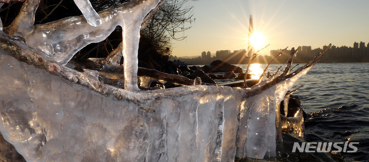 [서울=뉴시스] 이영환 기자 = 서울의 아침기온이 영하 11도를 보인 지난 12일 오전 서울 광진구 뚝섬한강공원변 얼음 뒤로 해가 떠오르고 있다. 2022.01.12. 20hwan@newsis.com