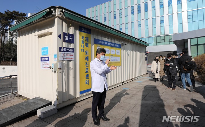 [서울=뉴시스] 사진공동취재단 = 김석연 서울의료원 의무부원장이 13일 서울 중랑구 서울의료원 코로나19 재택 외래진료센터 앞에서 시설에 대해 설명하고 있다. 외래진료센터는 재택치료 대상자가 재택치료 관리의료기관에서 대면진료의 필요성이 인정되는 경우, 가까운 외래진료센터를 예약하면 이용할 수 있다. 2022.01.13. photo@newsis.com