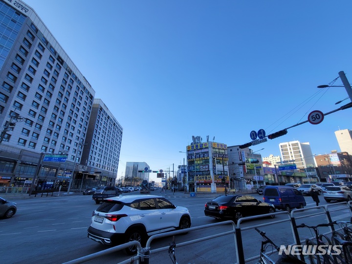 [서울=뉴시스]윤현성 수습기자=지난 11일 서울 강서구 가양동 양천향교역 사거리에서 보행자가 횡단보도를 건너고 있는 가운데 우회전 중인 차량들이 횡단보도를 침범해 정지해 있다. 오는 7월부터는 교차로에서 우회전을 할 때 횡단보도 옆 인도에 사람이 보이면 '일단 정지' 해야 한다. 2022.01.14. hsyhs@newsis.com