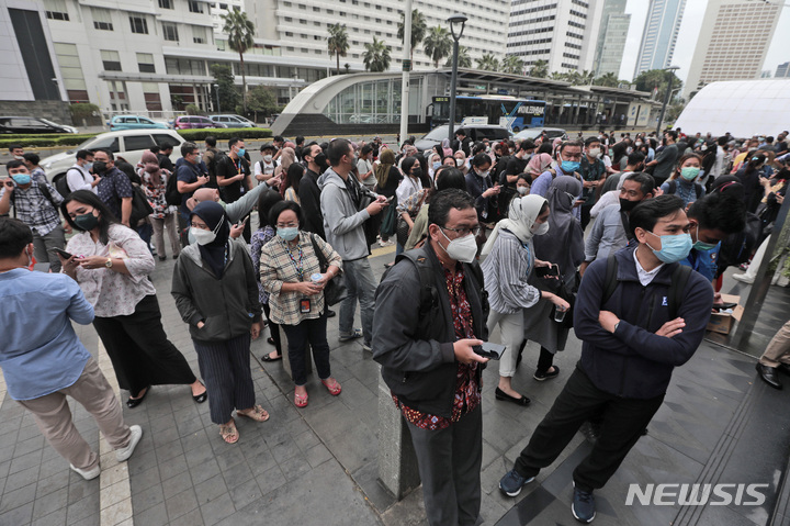 [AP/뉴시스] 14일 인니 수도 자카르타에서 해저 강진 발생에 건물이 흔들리자 사람들이 빠져나와 바깥에서 모여있다 