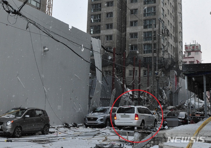[광주=뉴시스] 이영주 기자 = 지난 11일 오후 광주 서구 화정동 현대산업개발 신축아파트 붕괴 현장에서 무너진 외벽에 깔린 주정차차량. 빨간 원 안의 흰색 승합차가 사고 직후 인근 이면도로에서 주행 중 가까스로 화를 면한 A(56)씨의 차량. (사진=뉴시스DB) 2022.01.11. leeyj2578@newsis.com