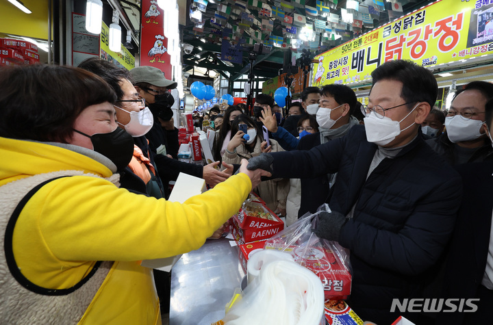 [강릉=뉴시스] 최동준 기자 = 이재명 더불어민주당 대선 후보가 16일 강원 강릉 중앙성남전통시장을 방문해 상인들과 인사하고 있다. (공동취재사진) 2022.01.15. photo@newsis.com