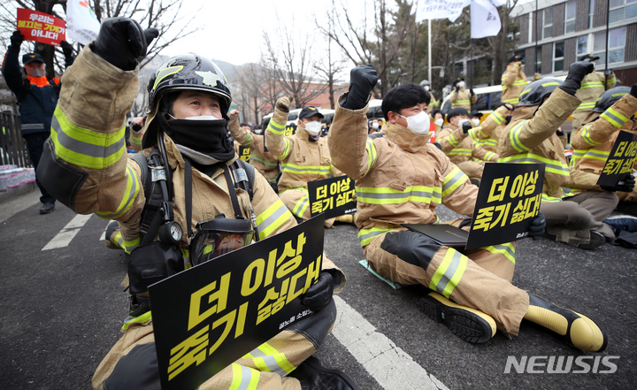 [서울=뉴시스] 조성우 기자 = 대한민국공무원노동조합총연맹 소방공무원노동조합 조합원들이 17일 오후 서울 종로구 청운동 사무소 앞에서 열린 '더 이상 죽기 싫다! 공노총 소방노조 대정부 규탄대회'에서 구호를 외치고 있다. 2022.01.17. xconfind@newsis.com