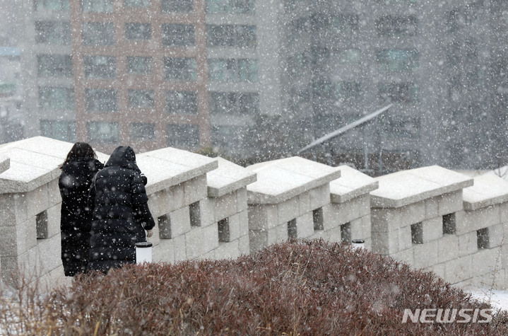 [서울=뉴시스] 고범준 기자 = 서울의 체감온도가 영하권을 맴돌며 눈이 내리는 지난 17일 오후 서울 중구 남산공원 백범광장에서 시민들이 걷고 있다. 2022.01.17. bjko@newsis.com