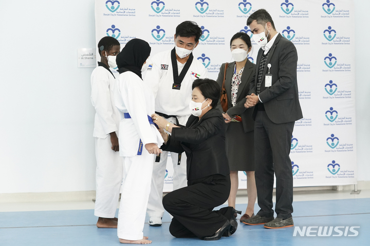 [두바이=뉴시스] 김진아 기자 = 문재인 대통령과 함께 UAE를 순방 중인 김정숙 여사가 17일(현지시각) 아랍에미리트 두바이 샤르자 인도주의 복지센터를 방문해 청각 장애 태권도 수업을 듣는 한 학생 도복의 띠를 매주고 있다. 2022.01.17. bluesoda@newsis.com