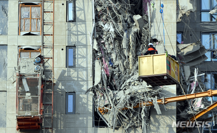 [광주=뉴시스] 류형근 기자 = 광주 서구 화정동 현대아이파크 신축 아파트 붕괴 사고 7일째인 17일 오후 구조안전 자문단들이 크레인을 이용해 붕괴 사고가 발생한 지점을 살펴보고 있다. 2022.01.17. hgryu77@newsis.com