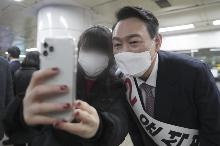 [서울=뉴시스] 최진석 기자 = 윤석열 국민의힘 대선 후보가 17일 저녁 서울 을지로입구역에서 퇴근하는 시민과 셀카를 찍고 있다. (사진=국민의힘 제공) 2022.01.17. photo@newsis.com *재판매 및 DB 금지