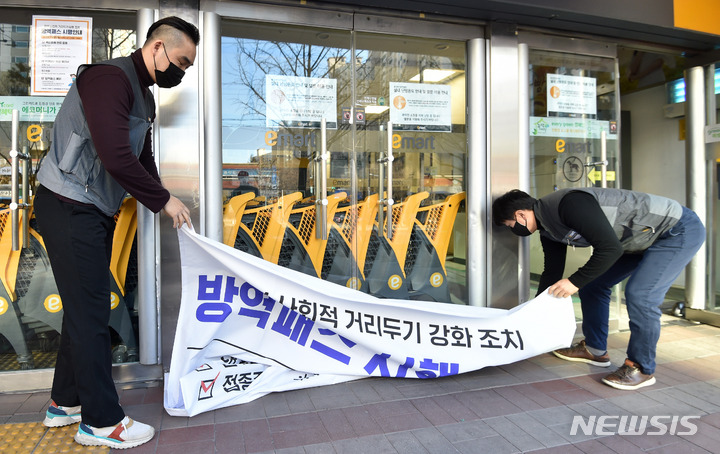 [대구=뉴시스] 이무열 기자 = 대형마트, 도서관, 학원 등에 적용되던 방역패스가 해제된 18일 오전 대구 수성구 만촌동 이마트 관계자들이 방역패스(접종증명·음성확인제) 운영 안내문 현수막을 회수하고 있다. 2022.01.18. lmy@newsis.com