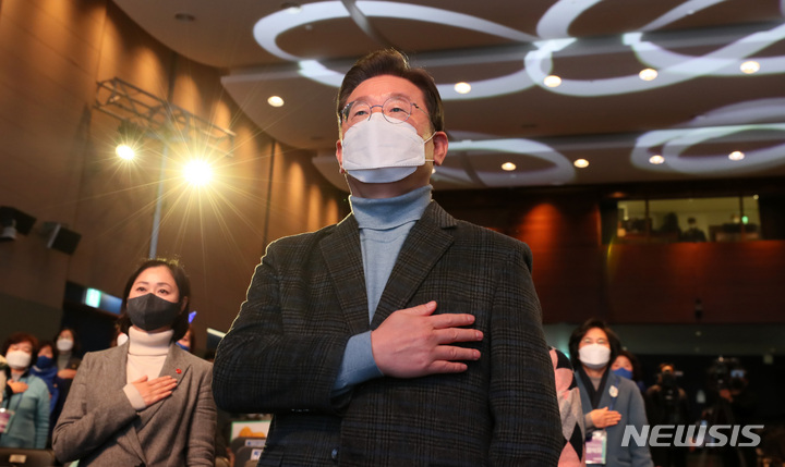 [서울=뉴시스] 국회사진기자단 = 이재명 더불어민주당 대선후보가 18일 서울 마포구 누리꿈스퀘어에서 열린 '중앙선대위 여성위원회 필승결의대회'에 참석해 국민의례를 하고 있다. 2022.01.18. photo@newsis.com
