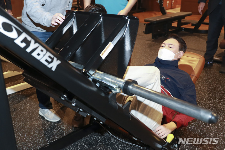 [서울=뉴시스] 전신 기자 = 윤석열 국민의힘 대선 후보가 18일 서울 강남구 한 실내 피트니스 센터를 방문해 실내체육시설 종사자들과 간담회 마친 후 레그프레스를 하고 있다. 2022.01.18. photo@newsis.com