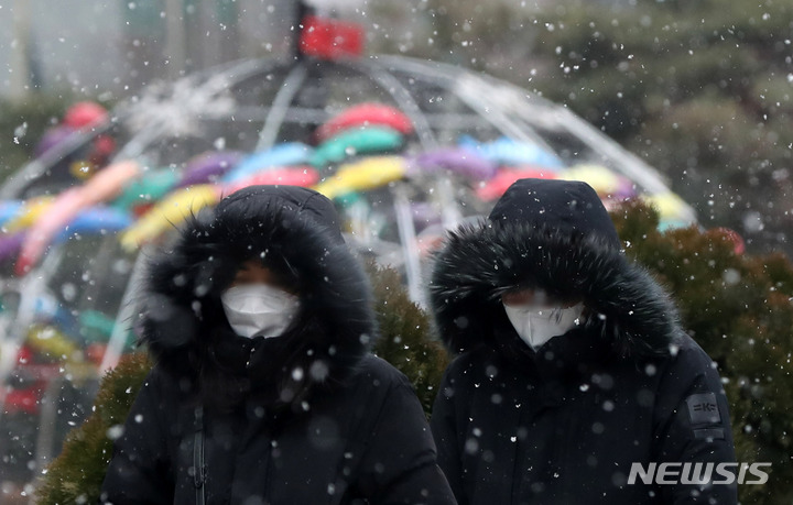 [서울=뉴시스] 추상철 기자 = 출근길 눈이 내린 지난 19일 오전 서울 도심에서 시민들이 눈을 맞으며 발걸음을 재촉하고 있다. 2022.01.19. scchoo@newsis.com