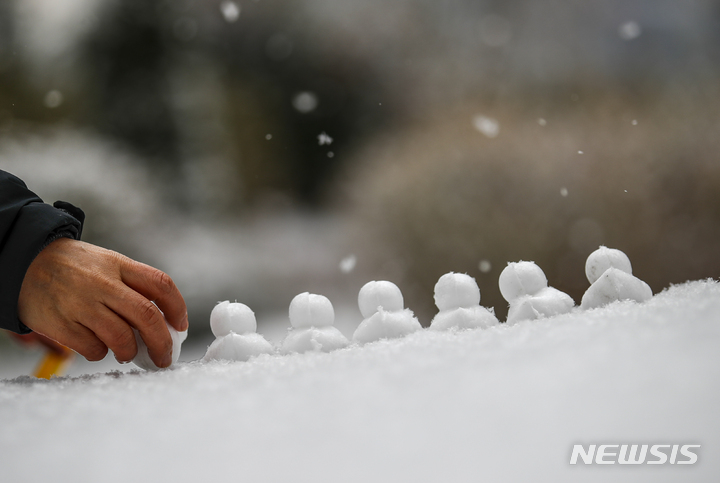 [서울=뉴시스] 정병혁 기자 = 지난 19일 오전 서울 용산구 용산역에서 한 시민이 눈오리를 만들고 있다. 2022.01.19. jhope@newsis.com