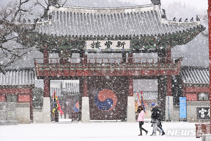[수원=뉴시스] 김종택기자 = 수도권지역에 대설주위보가 내려진 지난달 19일 오후 경기도 수원시 팔달구 화성행궁에서 시민들이 함박눈을 맞으며 걸어가고 있다. 2022.01.19. jtk@newsis.com