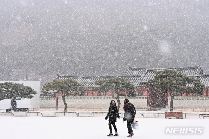 [수원=뉴시스] 김종택기자 = 수도권지역에 대설주위보가 내려진 지난달 19일 오후 경기도 수원시 팔달구 화성행궁에서 시민들이 함박눈을 맞으며 걸어가고 있다. 2022.01.19. jtk@newsis.com