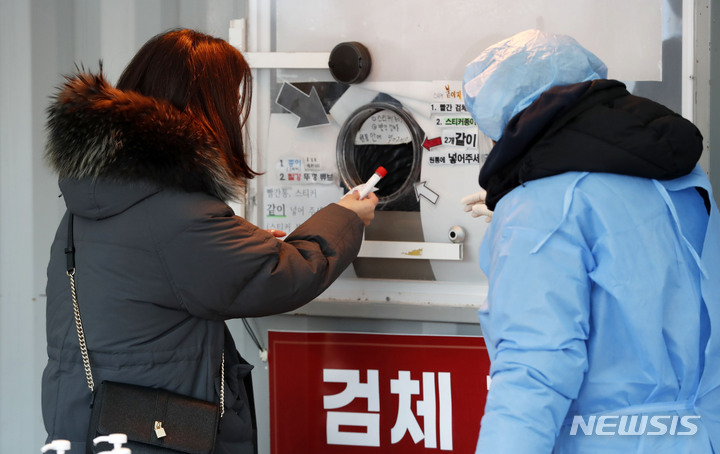[서울=뉴시스] 홍효식 기자 = 지난 21일 오전 서울시청 앞 서울광장 임시선별검사소에서 시민들이 검사를 받은 뒤 검체를 제출하고 있다. 2022.01.21. yesphoto@newsis.com