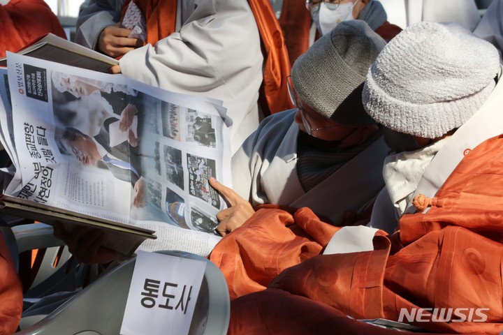 [서울=뉴시스] 박진희 기자 = 종교편향 근절과 한국불교 자주권 수호를 위한 '전국승려대회'에 참석한 한 스님들이 21일 서울 종로구 조계사 대웅전 앞에서 행사 시작을 기다리며 신문을 보고 있다. 2022.01.21. pak7130@newsis.com