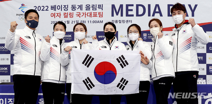 [강릉=뉴시스] 김병문 기자 = 여자 컬링 국가대표팀 '팀 킴'이 21일 오전 강원 강릉시 강릉컬링센터에서 열린 컬링 미디어데이 및 2022 베이징 동계올림픽 출정식에서 태극기에 사인을 한 뒤 기념촬영하고 있다. 왼쪽부터 김용빈 대한컬링연맹 회장, 김은정, 김영미, 김경애, 김선영, 김초희, 임명섭 감독. 2022.01.21. dadazon@newsis.com