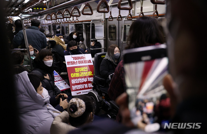[서울=뉴시스] 고범준 기자 = 전국장애인차별철폐연대, 전국장애인이동권연대 등 회원들이 지난달 21일 오후 서울 종로구 혜화역 오이도역 방향 승강장 앞에서 오이도역 장애인리프트 추락 참사 21주기 장애인권리예산 확보를 위한 자하철 여행 및 캠페인을 진행하고 있다. 2022.02.10. bjko@newsis.com