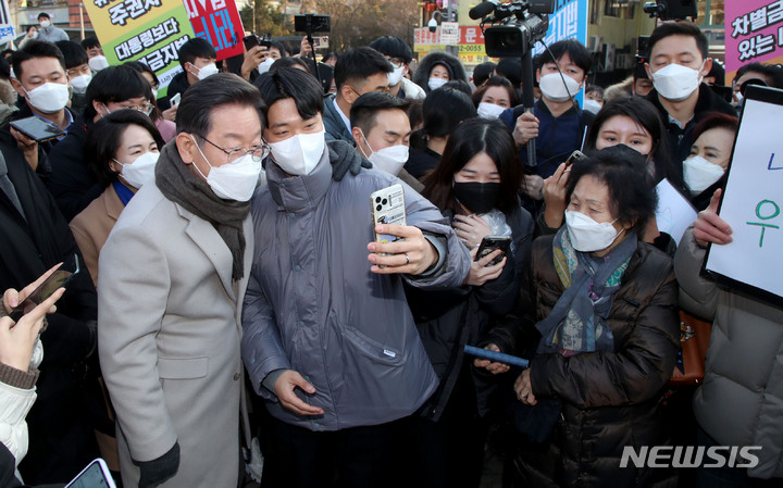 [서울=뉴시스] 국회사진기자단 = 이재명 더불어민주당 대선 후보가 21일 서울 마포구 연남동 거리를 방문해 시민들과 기념촬영을 하고 있다. 2022.01.21. photo@newsis.com