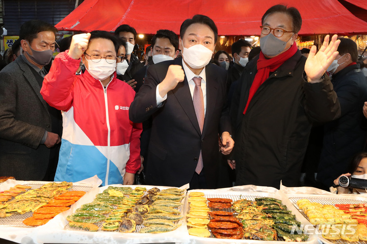 [대전=뉴시스] 전신 기자 = 윤석열 국민의힘 대선 후보가 21일 대전 동구 중앙시장을 방문해 전을 구입하며 상인과 인사하고 있다. 2022.01.21. photo1006@newsis.com