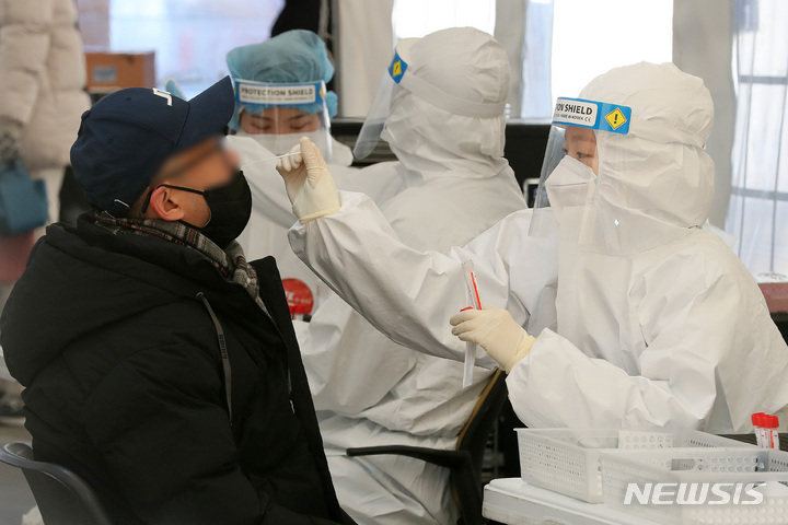[서울=뉴시스] 백동현 기자 = 코로나19 신규 확진자가 7,513명으로 3일 연속 7천 명대를 기록한 24일 오전 서울 강남구 삼성역 임시선별검사소에서 의료진이 검체를 채취하고 있다. 2022.01.24. livertrent@newsis.com