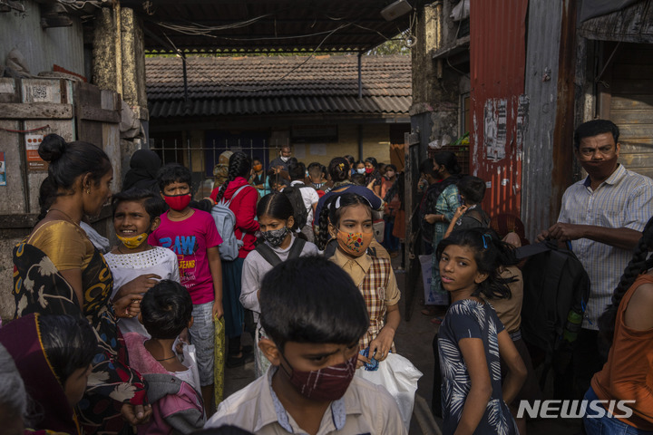 [뭄바이=AP/뉴시스] 24일(현지시간) 인도 뭄바이의 아시아 최대 슬럼가 다라비에서 마스크를 쓴 학생들이 수업을 마치고 학교를 나서고 있다. 2022.01.24
