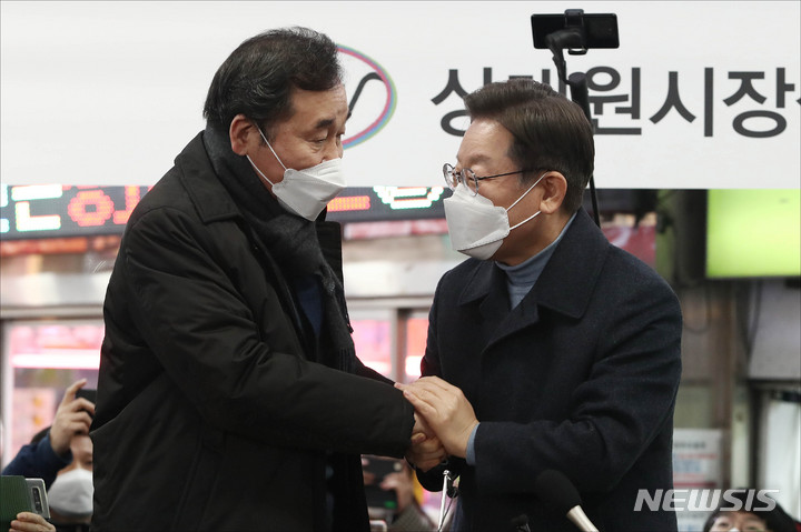 [성남=뉴시스] 김선웅 기자 = 이재명 더불어민주당 대선 후보가 24일 오후 경기 성남시 중원구 상대원시장에서 열린 '매타버스' 성남, 민심속으로! 행사에서 이낙연 전 대표와 손을 맞잡고 있다. (공동취재사진) 2022.01.24. photo@newsis.com