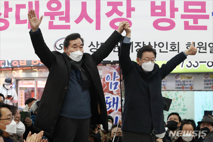 [성남=뉴시스] 김선웅 기자 = 이재명 더불어민주당 대선 후보가 24일 오후 경기 성남시 중원구 상대원시장에서 열린 '매타버스' 성남, 민심속으로! 행사에서 이낙연 전 대표와 손을 들어올리고 있다. (공동취재사진) 2022.01.24. photo@newsis.com