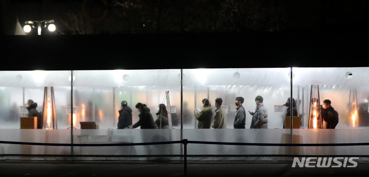 [서울=뉴시스] 추상철 기자 = 코로나19의 신규 확진자가 급속한 확산세를 보인 24일 오후 서울 송파구 잠실종합운동장 제2주차장 임시선별검사소에서 밤 늦은 시간에도 코로나19 검사를 받으려는 시민들이 길게 줄지어 서 있다. 2022.01.24. scchoo@newsis.com