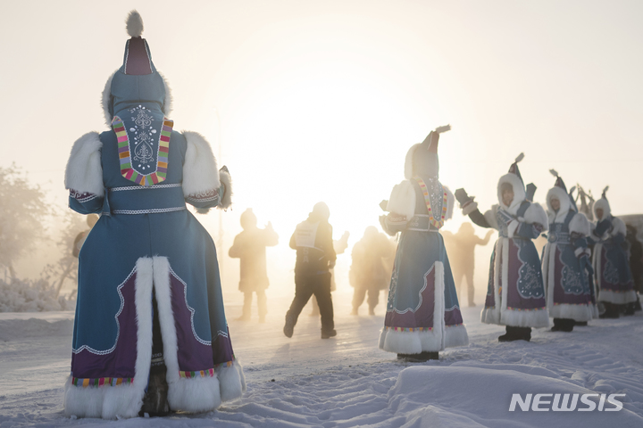 [오이먀콘=AP/뉴시스] 22일(현지시간) 러시아 극동 야쿠티아라고도 알려진 사하공화국의 오이먀콘 인근에서 영하 53도 속 세계에서 가장 추운 국제 마라톤이 열려 야쿠티아 전통 의상을 입은 여성들이 선수들을 응원하고 있다. 이 대회엔 아랍에미리트, 미국, 벨라루스 등 65명의 남녀 주자가 참가해 풀코스와 하프 코스를 달렸다. 이 마을은 인간이 거주하는 곳 중 가장 추운 곳이며 얼지 않는 물인 자연 온천이 있다. 2022.01.25.