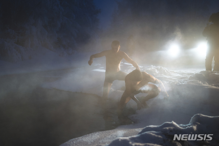 [오이먀콘=AP/뉴시스] 22일(현지시간) 러시아 극동 야쿠티아라고도 알려진 사하공화국의 오이먀콘 인근에서 열린 영하 53도 속 국제 마라톤 참가자들이 따뜻한 온천에서 몸을 녹이고 있다. 이 대회엔 아랍에미리트, 미국, 벨라루스 등 65명의 남녀 주자가 참가해 풀코스와 하프 코스를 달렸다. 이 마을은 인간이 거주하는 곳 중 가장 추운 곳이며 얼지 않는 물인 자연 온천이 있다. 2022.01.25.