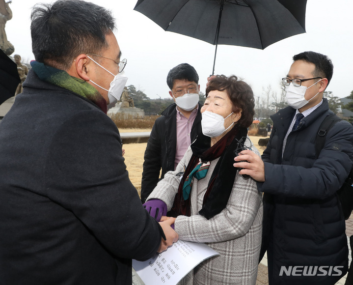 [서울=뉴시스] 조수정 기자 = 일본군 위안부 피해자 이용수 할머니가 25일 서울 종로구 청와대 분수대 앞에서 문재인 대통령에게 전달할 위안부 문제의 유엔 고문방지위원회(CAT) 회부 촉구 서한을 육성철 청와대 행정관에게 건네며 손을 붙잡고 있다. 2022.01.25. chocrystal@newsis.com