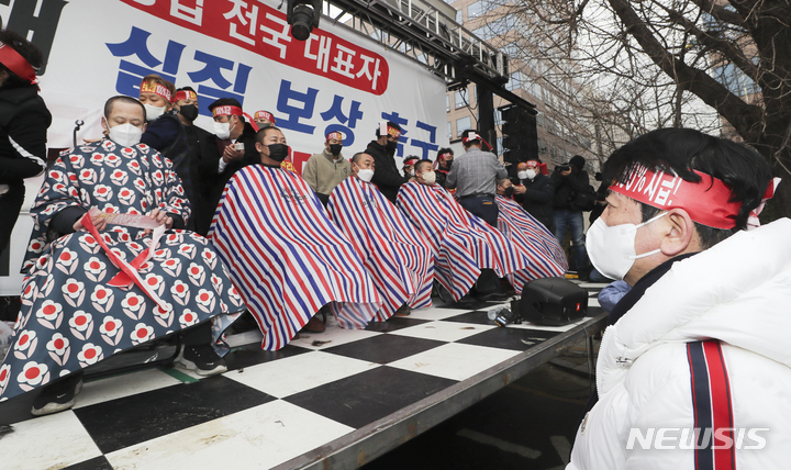 [서울=뉴시스] 최진석 기자 = 코로나 피해 자영업 총연대 회원들이 25일 오후 서울 여의도 국회 인근에서 열린 '299인 릴레이 삭발식'에서 삭발을 하고 있다. 2022.01.25. myjs@newsis.com