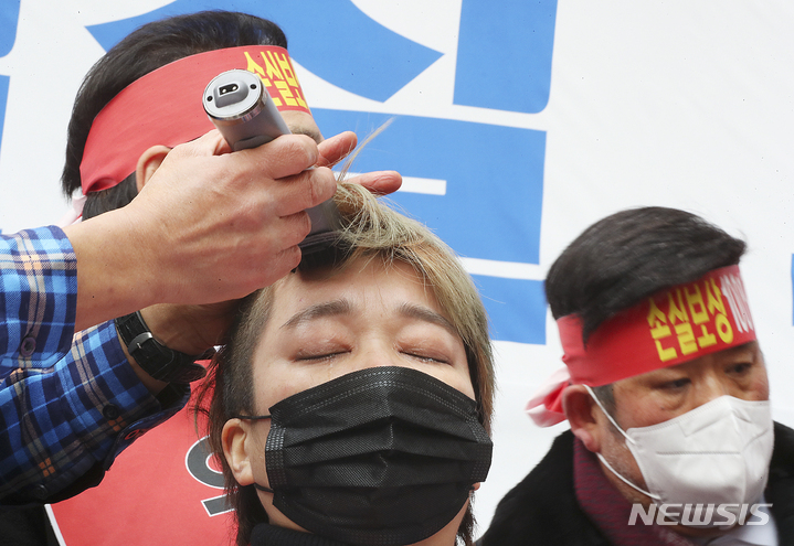 [서울=뉴시스] 최진석 기자 = 코로나 피해 자영업 총연대 회원이 25일 오후 서울 여의도 국회 인근에서 열린 '299인 릴레이 삭발식'에서 삭발을 하고 있다. 2022.01.25. myjs@newsis.com