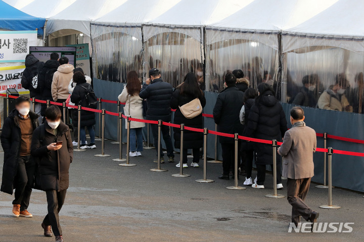 [서울=뉴시스] 백동현 기자 = 코로나19 신규 확진자가 13,012명으로 역대 최다를 기록한 26일 오전 서울 중구 서울역광장 임시선별검사소에서 시민들이 검사를 받기 위해 대기하고 있다. 2022.01.26. livertrent@newsis.com