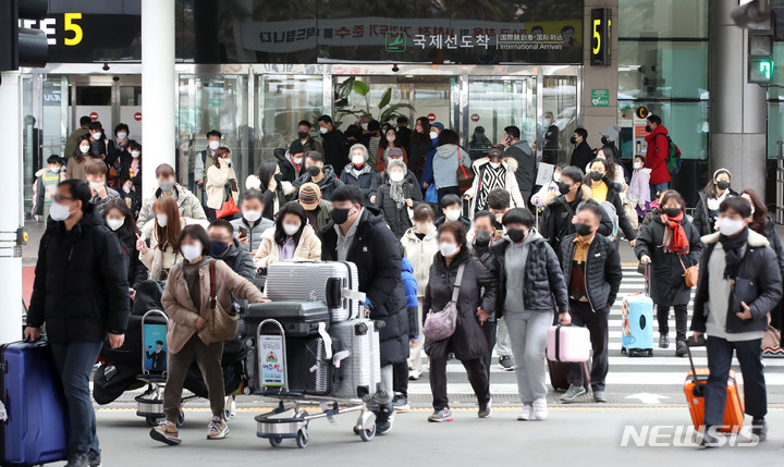 [제주=뉴시스] 우장호 기자 = 오미크론 변이바이러스 여파로 신규 코로나19 확진자가 이틀째 1만 명대를 기록한 지난 27일 오전 제주국제공항 1층 도착장에 관광객들의 발걸음이 이어지고 있다. 2022.01.27. woo1223@newsis.com