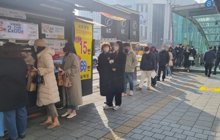 [서울=뉴시스] 신재현 기자=지난 27일 오후 서울 잠실역 근처 복권 판매점 앞에 복권을 사려는 사람들이 줄을 서 있다. 2022.01.28. photo@newsis.com *재판매 및 DB 금지