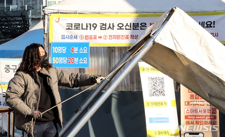 [서울=뉴시스] 김병문 기자 = 28일 오전 서울 중구 서울역에 마련된 임시선별검사소에서 관계자가 자가진단키트를 이용한 신속항원검사를 위한 천막을 추가 설치하고 있다. 2022.01.28. dadazon@newsis.com